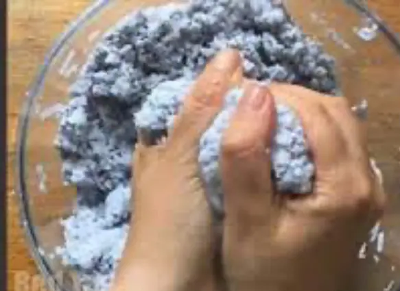 يد تعصر عجينة الورق في وعاء.